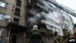 Firefighters work to extinguish a fire in a multi-story residential building hit by shelling, in Donetsk, Ukraine, Dec. 19, 2023.