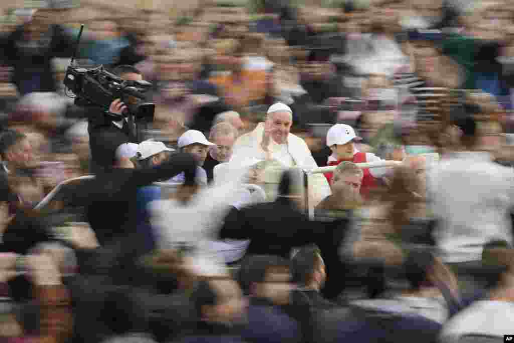 Pope Francis waves as he arrives for his weekly general audience in St. Peter's Square at The Vatican.