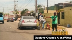 Revendedores de gasolina ofrecen varios litros de combustible en la calle 43 de Maracaibo, cerca de la urbanización San Jacinto, el mediodía del miércoles 14 de junio de 2023.