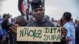 Um homem segura um cartaz durante os protestos da Renamo contra os resultados das eleições autárquicas em Maputo, a 17 de outubro de 2023