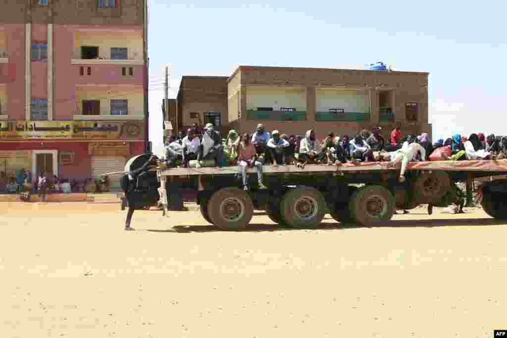 People fleeing street battles between the forces of two rival Sudanese generals are transported on the back of a truck in the southern part of Khartoum.