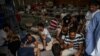 Migrants who were rescued at open sea off the coast of Greece after their boat capsized are seen inside a warehouse, used as a shelter, at the port of Kalamata, Greece, June 15, 2023.