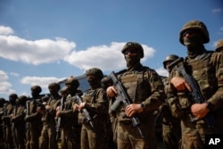 Polish servicemen attend a press conference of Poland's Minister of Defense, Mariusz Blaszczak, in Jarylowka, Poland, Aug. 12, 2023.