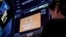 A trader works at the post where Alibaba is traded on the floor of the New York Stock Exchange in New York, March 28, 2023.