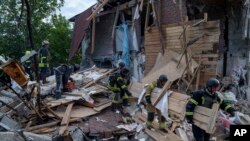Rescue workers clear the rubble of a building which was destroyed by a Russian airstrike in Kharkiv, Ukraine, June 10, 2024.