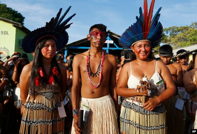 Macuxi Indigenous youths pose for a photos at the Caracarana Lake Regional Center in Normandia, on the Raposa Serra do Sol Indigenous reserve in Roraima state, Brazil, Monday, March 13, 2023. (AP Photo/Edmar Barros)