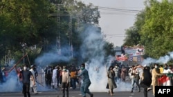 Pakistan Tehreek-e-Insaf (PTI) party activists and supporters of former Pakistan's Prime Minister Imran clash with police during a protest against the arrest of Former Pakistan prime minister Imran Khan, in Lahore on May 9, 2023.
