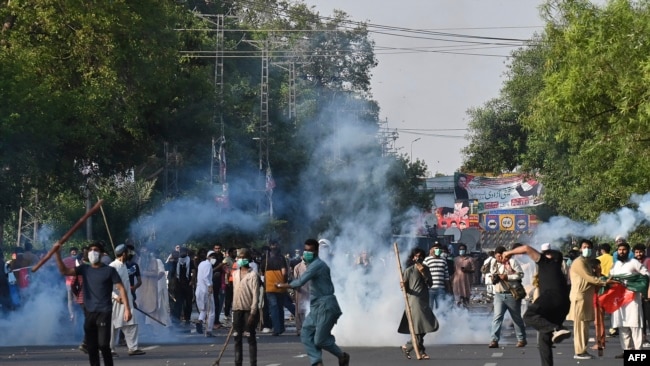 Pakistan Tehreek-e-Insaf (PTI) party activists and supporters of former Pakistan's Prime Minister Imran clash with police during a protest against the arrest of Former Pakistan prime minister Imran Khan, in Lahore on May 9, 2023.