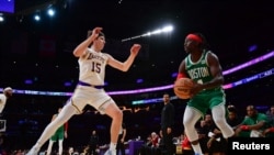 Jrue Holiday (4) des Boston Celtics, contrôle le ballon contre Austin Reaves (15) des Los Angeles Lakers, Los Angeles, le 25 décembre 2023.