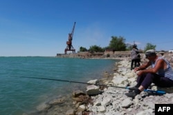 A man fishes in Lake Balkhash in the town of Balkhash, Kazakhstan, on June 19, 2024.