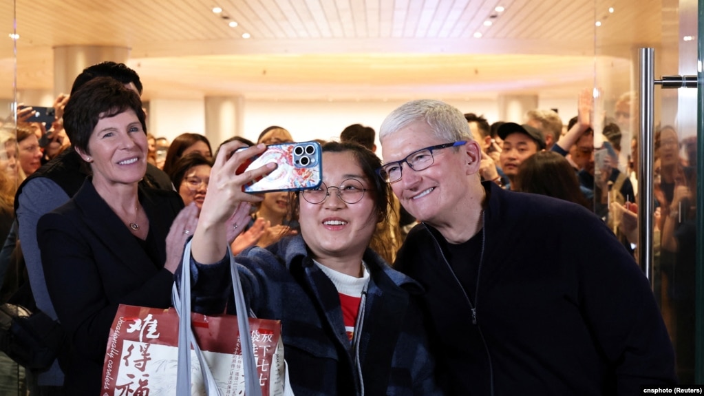 苹果公司首席执行官库克在上海出席第二家专卖店开张活动时与一名顾客合影。（2024年3月21日）