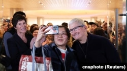 蘋果行政總裁庫克在上海出席第二家專賣店開張活動時與一名顧客合影。（2024年3月21日）