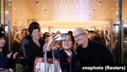苹果公司首席执行官库克在上海出席静安区专卖店开张营业活动时与一名顾客合影。（2024年3月21日）