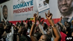 Pessoas reúnem-se em frente à sede do candidato Bassirou Diomaye Faye, em Dakar, a 24 de março de 2024, enquanto se esperam os resultados das eleições presidenciais senegalesas. 