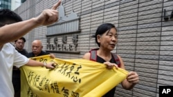 Members of League of Social Democrats hold banner outside the West Kowloon Magistrates' Courts in Hong Kong, May 30, 2024, ahead of verdicts in a national security case.