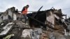 A volunteer inspects the ruins of a residential building hit by a Russian missile strike in Zaporizhzhia, Ukraine, April 9, 2023. 