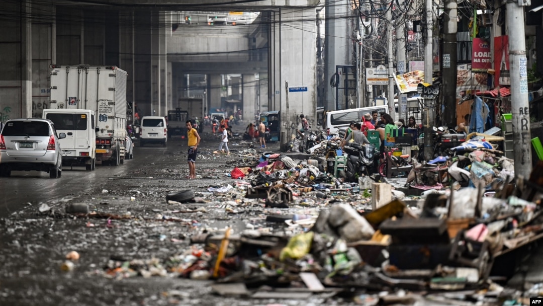 Residents look at their belongings in the aftermath of Typhoon Gaemi in Manila on July 25, 2024.