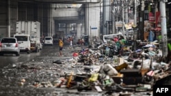 Residents look at their belongings in the aftermath of Typhoon Gaemi in Manila on July 25, 2024.