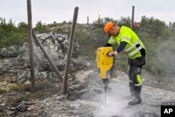 A man works to build a new fence along the border with Russia, next to Storskog, Norway, Aug. 23, 2023.