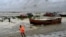 A man pulls a fishing boat to shore as a preventive measure during rainfall in Kuakata, Bangladesh, on May 26, 2024, ahead of cyclone Remal's landfall.