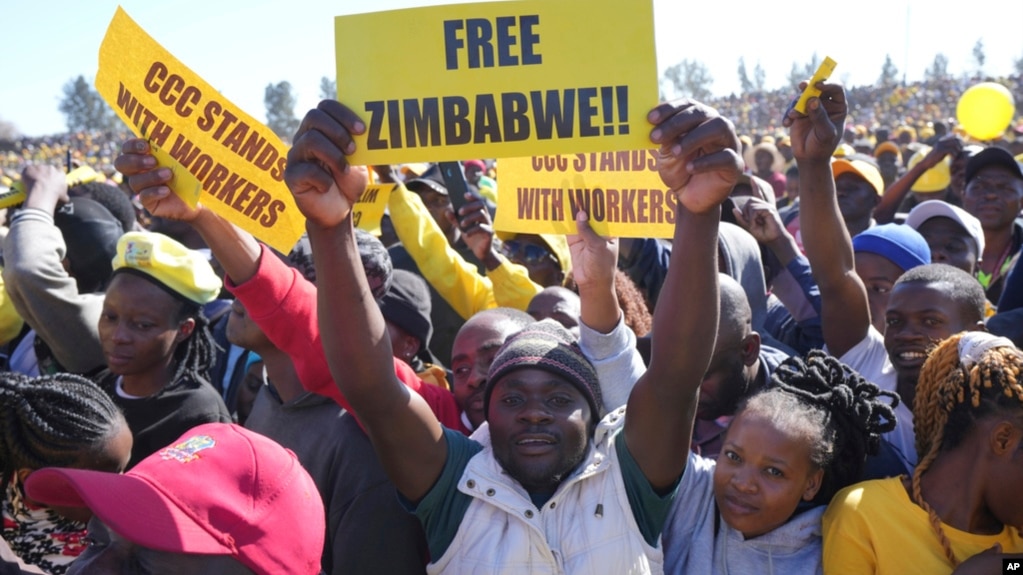 FILE - Supporters of Zimbabwe's main opposition leader Nelson Chamisa hold placards upon his arrival for a a rally on the outskirts of Harare on July 17, 2023.