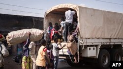 FILE: Asylum Seekers from the Democratic Republic of Congo (DRC) are guided to wait on a truck after crossing a border to be transferred in Bunagana, Uganda, on June 7, 2022, 