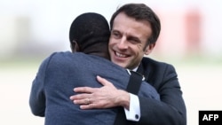 French President Emmanuel Macron greets French journalist Olivier Dubois upon the journalist's arrival at an airport near Paris on March 21, 2023. Dubois had just been freed after behind held hostage in Mali for nearly two years.