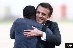 French President Emmanuel Macron greets French journalist Olivier Dubois upon the journalist's arrival at Villacoublay airport near Paris, on March 21, 2023. Dubois had just been freed after behind held hostage in Mali for nearly two years.