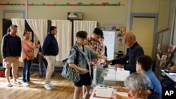 Uma mulher vota na segunda volta das eleições legislativas, a 7 de julho de 2024, em Rennes, no oeste de França. 