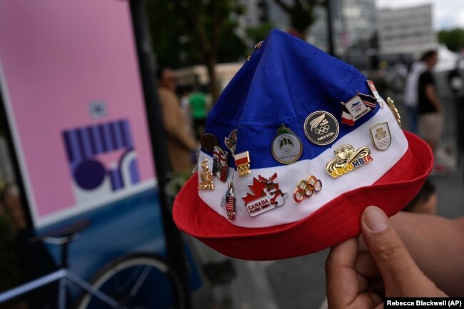 Warga sekitar, Lahlouh Wahab, memamerkan semua pin Olimpiade 2024 yang berhasil dikumpulkannya di Olimpiade Musim Panas 2024, Selasa, 23 Juli 2024, di Paris, Prancis. (Foto: AP/Rebecca Blackwell)