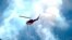 A helicopter heads toward a ridge to make a water drop on a wildland fire burning near the Ken Caryl Ranch development July 31, 2024, southwest of Littleton, Colo.