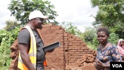 FILE - Entrepreneur Kondwani Ngwira chats with a cyclone survivor in Blantyre, Malawi.