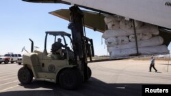 Petugas menurunkan pasokan medis dan barang-barang bantuan dari pesawat kargo yang tiba dari Uni Emirat Arab di Bandara Internasional Benina di Benghazi, Libya, 15 September 2023, untuk bantuan bagi korban banjir di Derna dan daerah sekitarnya. (REUTERS/Amr Alfiky)