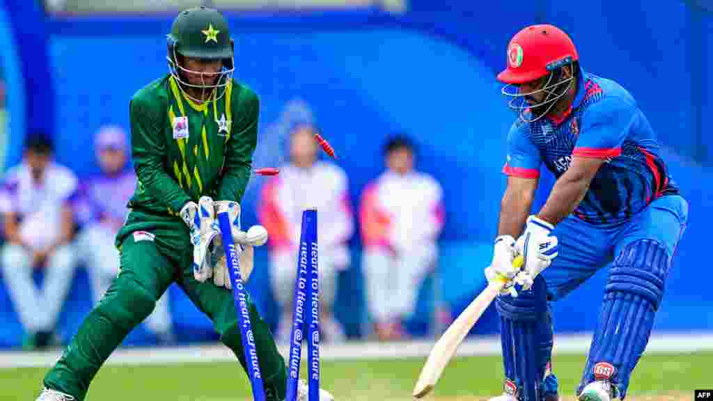 Afghanistan's Mohammad Shahzad (R) is dismissed by Pakistan's Arafat Minhas during the 2022 Asian Games men's second semi-final cricket match in Hangzhou, China.