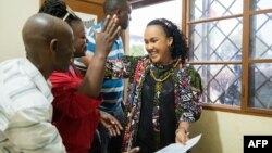 Burundian journalist Floriane Irangabiye, right, greets members of her legal team after walking out of the Bubanza Prison on Aug. 16, 2024, following a presidential pardon.