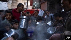 Warga Palestina antre untuk mendapatkan makanan berbuka puasa berupa sup dan bubur gandum di Gaza, pada 26 Maret 2023. (Foto: AP/Fatima Shbair)