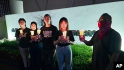 In this image taken and provided by Anti-Death Penalty Asia Network, members of Anti-Death Penalty Asia Network (ADPAN) hold candle outside Singapore Embassy in Kuala Lumpur, Malaysia, April 26, 2023.