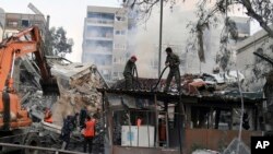 Emergency service workers clear the rubble at a destroyed building struck by Israeli jets in Damascus, Syria, April 1, 2024. (SANA via AP)