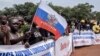 A demonstrator holds a Russian national flag during a rally in support of Russia's and China's presence in the Central African Republic, in the capital Bangui, March 22, 2023.