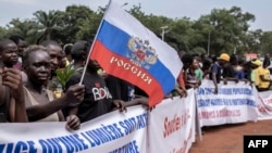 A demonstrator holds a Russian national flag during a rally in support of Russia's and China's presence in the Central African Republic, in the capital Bangui, March 22, 2023.