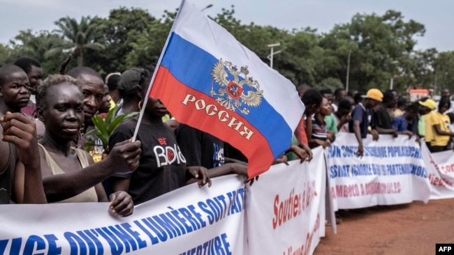 A demonstrator holds a Russian national flag during a rally in support of Russia's and China's presence in the Central African Republic, in the capital Bangui, March 22, 2023.