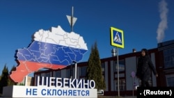  A woman walks past an installation with the slogan “Shebekino does not bow down,” in Shebekino, Russia, March 11, 2024.