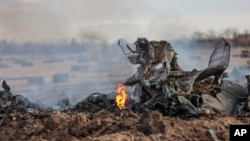 The wreckage of ta warplane burns after it crashed near Yenakijeve, Russian-controlled Donetsk region, eastern Ukraine, Friday, March 3, 2023.