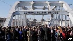 Arquivo - O Vice-Presidente Joe Biden e o congressista John Lewis, D-Ga., lideram um grupo através da Ponte Edmund Pettus em Selma, Ala., 3 de Março de 2013. 