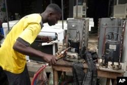 A man repairs air conditioners on the street in Lagos, Nigeria, July 15, 2024.