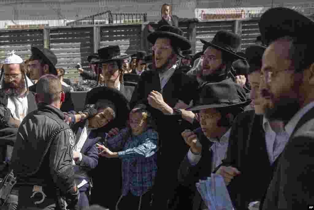 Israeli police officers scuffle with ultra-Orthodox Jewish men during a protest against a potential new draft law which could end their exemptions from military service in Jerusalem.