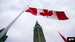 FILE - A Canadian flag flies in front of the peace tower on Parliament Hill in Ottawa, Canada, on Dec. 4, 2015.