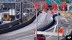 FILE - Diverted traffic, including an ambulance on a call, passes a closed portion of the Washington Bridge, March 8, 2024, in East Providence, Rhode Island. 