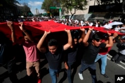 FILE - Demonstrators march in remembrance of the 1968 Tlatelolco student massacre, an event considered part of the Mexico's 'dirty war' when the government used its forces to suppress political opposition, in Mexico City, Oct. 2, 2019.