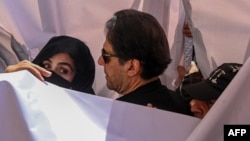 Mantan perdana menteri Pakistan Imran Khan (tengah) bersama istrinya Bushra Bibi (kiri) tiba untuk hadir di pengadilan tinggi di Lahore pada 15 Mei 2023. (Foto: AFP)